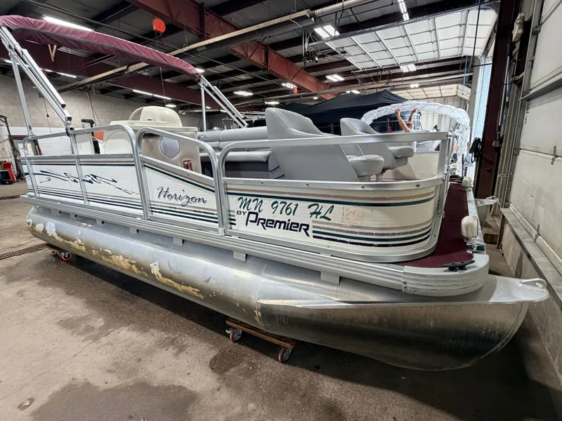 Slide: The Image of A 1998 Premier 180 Horizon pontoon boat with a 40HP Honda 4-stroke engine in a warehouse. - 50