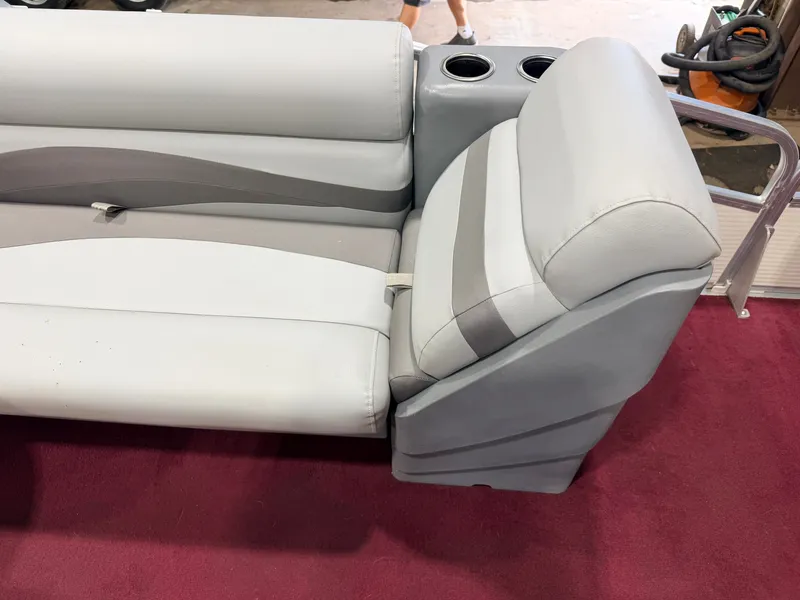 Slide: The Image of A gray and white seat on a boat with cup holders and red carpeting. - 29