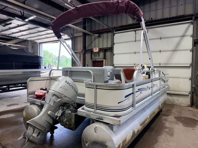 Slide: The Image of A 1998 Premier 180 Horizon pontoon boat with a 40HP Honda 4-stroke engine in a garage. - 45