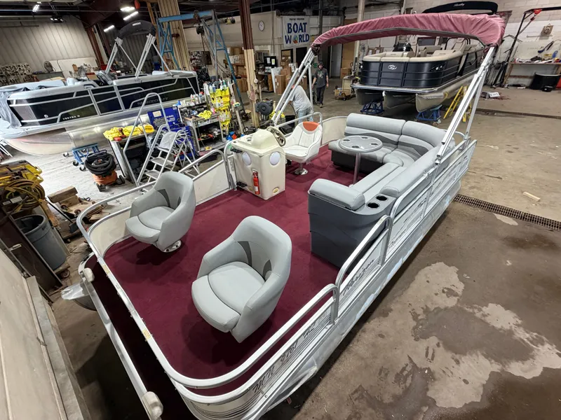 The Image of A 1998 Premier 180 Horizon pontoon boat with 40HP Honda 4-stroke engine, in a workshop. - 1
