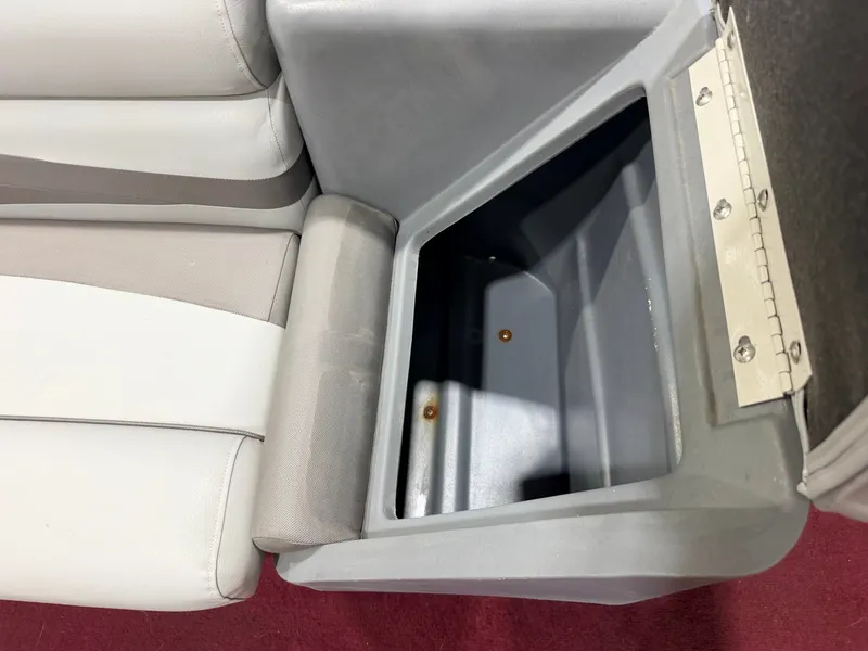 Slide: The Image of A gray storage compartment next to a cushioned seat on a boat. - 30
