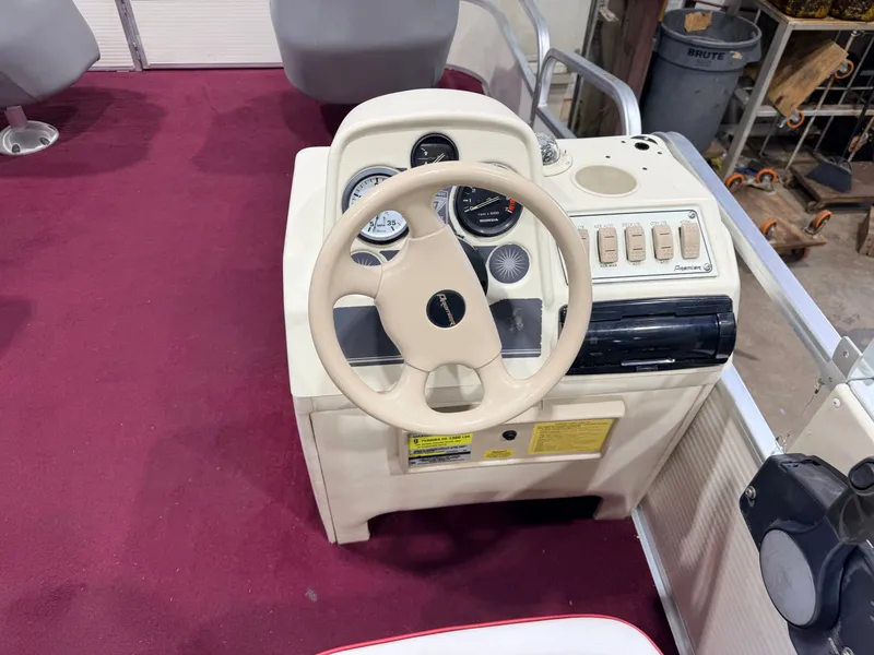 Slide: The Image of The image shows a boat's helm with a cream-colored steering wheel and instruments on red carpet. - 21