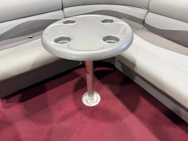 Slide: The Image of A gray table with four cup holders stands on red carpet in a boat. - 34