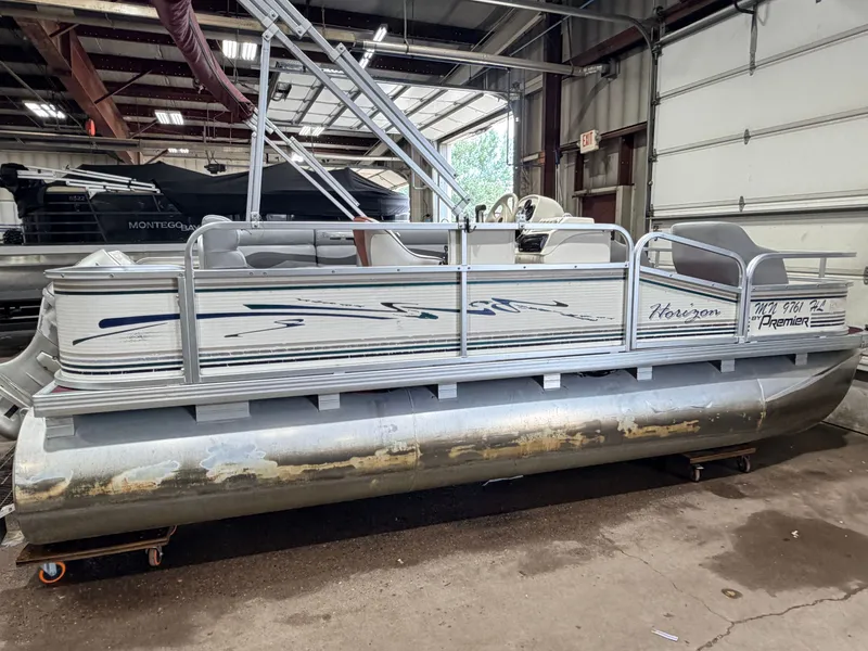 Slide: The Image of A 1998 Premier 180 Horizon pontoon boat with a 40HP Honda 4-stroke engine in a garage. - 48