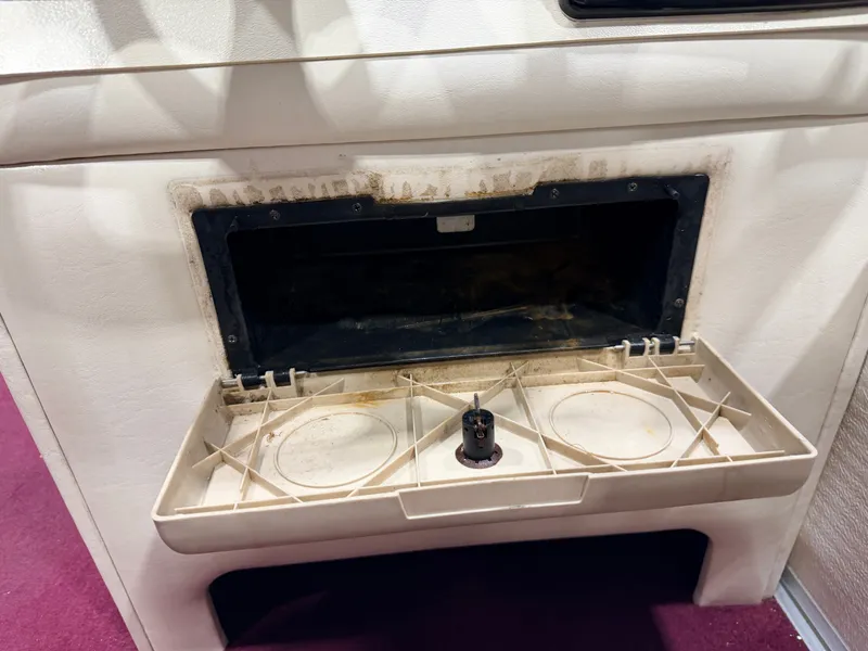 Slide: The Image of An open storage compartment with cup holders on a boat. - 26