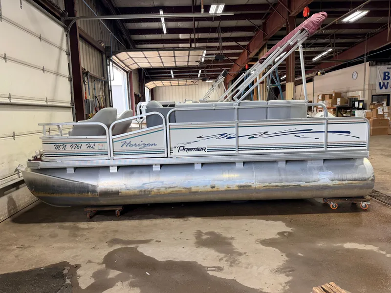 Slide: The Image of A 1998 Premier 180 Horizon pontoon boat with a 40HP Honda 4-stroke engine in a warehouse. - 27