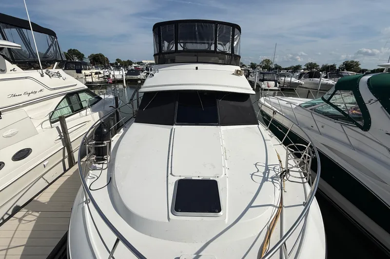 Slide: The Image of 1989 Carver 3807 Aft Cabin Motor Yacht docked at marina, surrounded by other boats. - 2