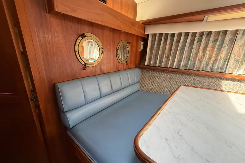 Slide: The Image of Interior of 1989 Carver 3807 Aft Cabin Motor Yacht with blue seating and portholes. - 51