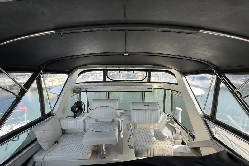 Slide: The Image of Interior view of 1989 Carver 3807 Aft Cabin Motor Yacht with white seating and panoramic windows. - 24