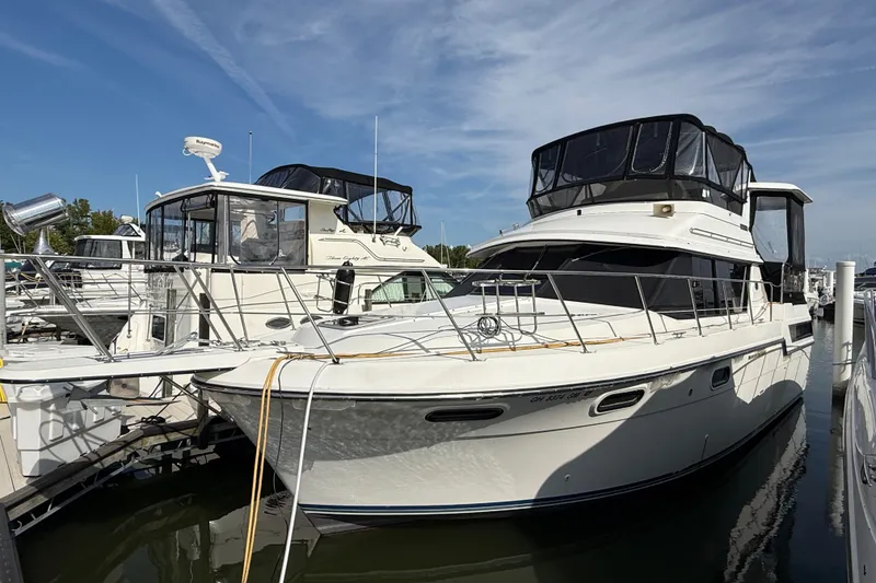 The Image of 1989 Carver 3807 Aft Cabin Motor Yacht docked at marina under clear sky. - 0