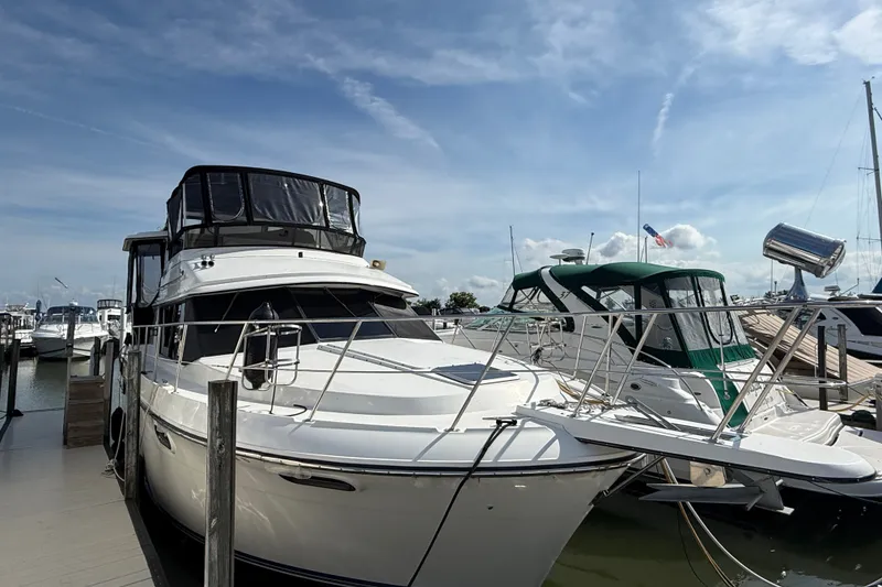 Slide: The Image of 1989 Carver 3807 Aft Cabin Motor Yacht docked at marina under clear sky. - 3