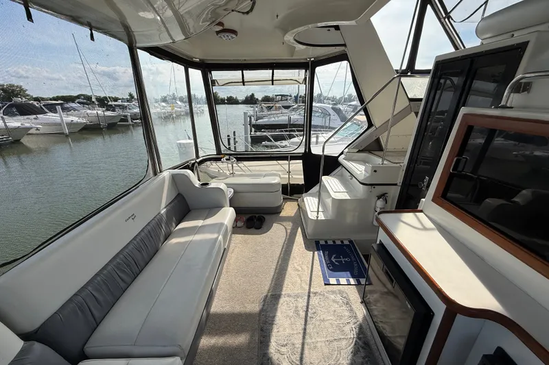 Slide: The Image of 1989 Carver 3807 Aft Cabin Motor Yacht interior with seating and marina view. - 9