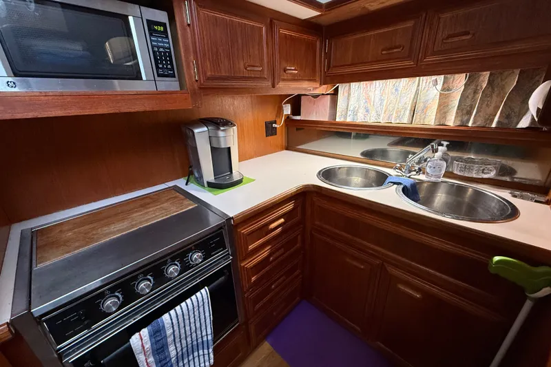 Slide: The Image of 1989 Carver 3807 Aft Cabin Motor Yacht kitchen with stove, microwave, and double sink. - 44