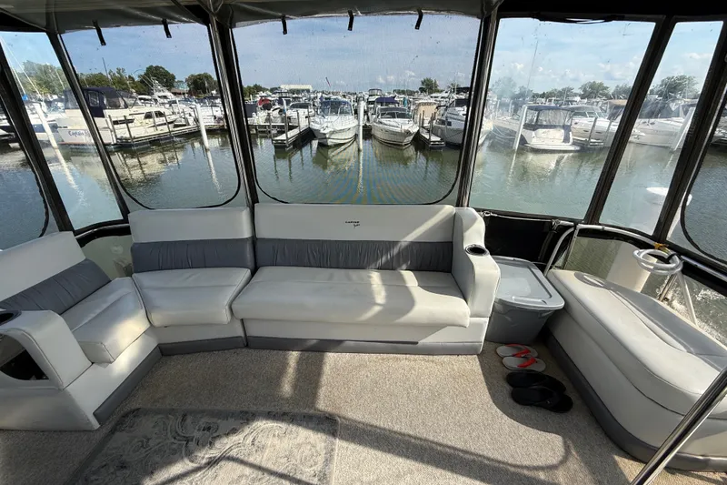 Slide: The Image of 1989 Carver 3807 Aft Cabin Motor Yacht interior with marina view and comfortable seating. - 10