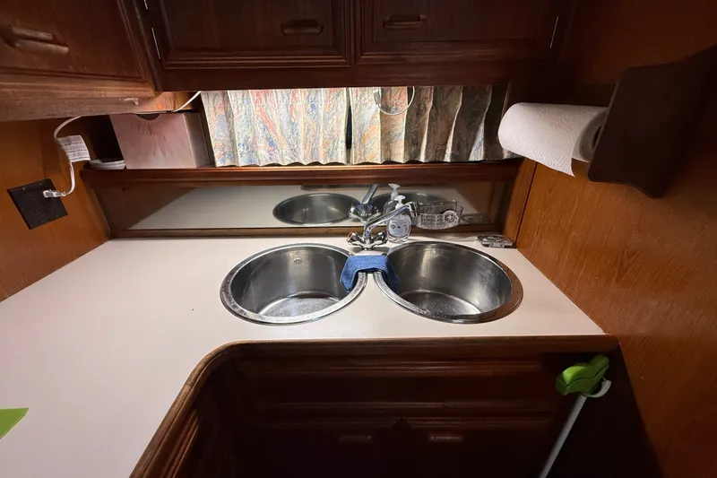 Slide: The Image of 1989 Carver 3807 Aft Cabin Motor Yacht kitchen with dual sinks and wooden cabinetry. - 48