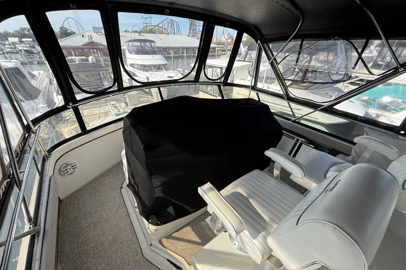 Slide: The Image of 1989 Carver 3807 Aft Cabin Motor Yacht helm with covered controls and white seating. - 17