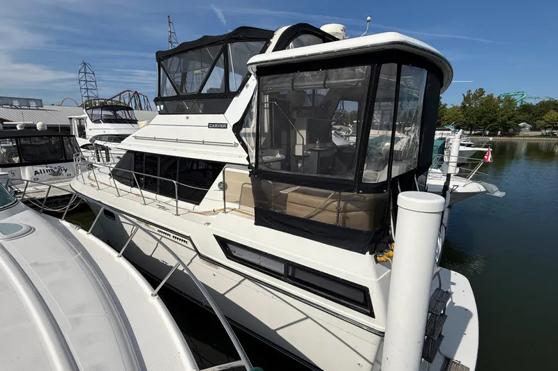 Slide: The Image of 1989 Carver 3807 Aft Cabin Motor Yacht docked at marina under clear sky. - 1