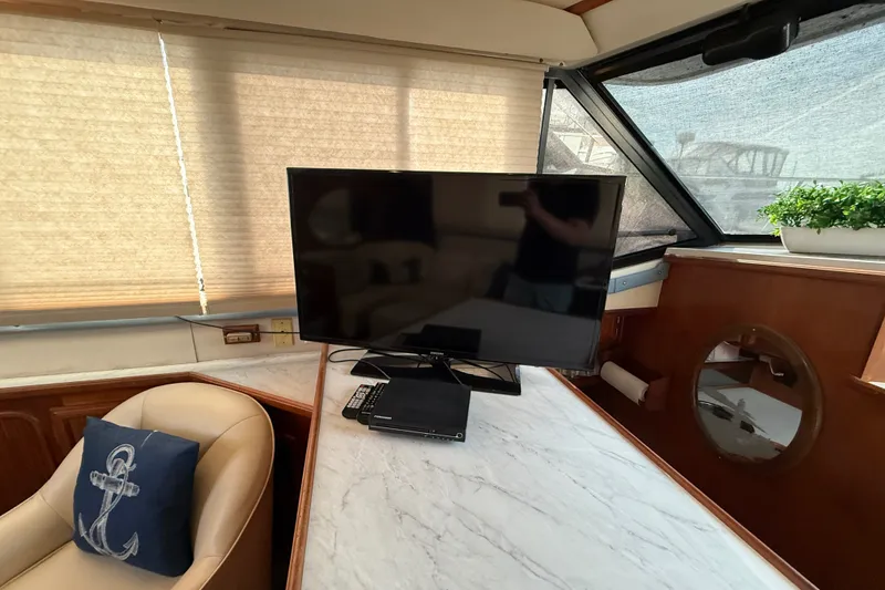 Slide: The Image of Interior of 1989 Carver 3807 Aft Cabin Yacht with TV and anchor-themed decor. - 35