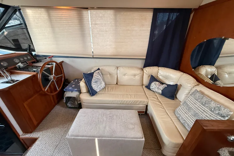 Slide: The Image of 1989 Carver 3807 Aft Cabin Motor Yacht interior with helm, beige seating, and nautical decor. - 30