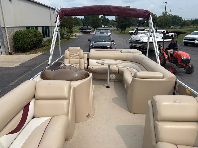 Slide: The Image of The image shows a 2012 Crest Classic 230L pontoon boat with beige seating and a table. - 8