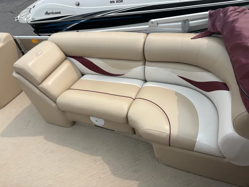 Slide: The Image of The boat seating is beige with maroon and white accents, well-cushioned. - 10