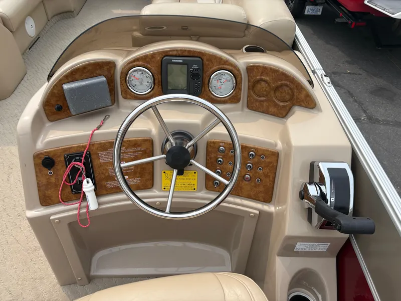 Slide: The Image of The image shows the helm of a 2012 Crest Classic 230L. It features a steering wheel, gauges, and controls. - 15