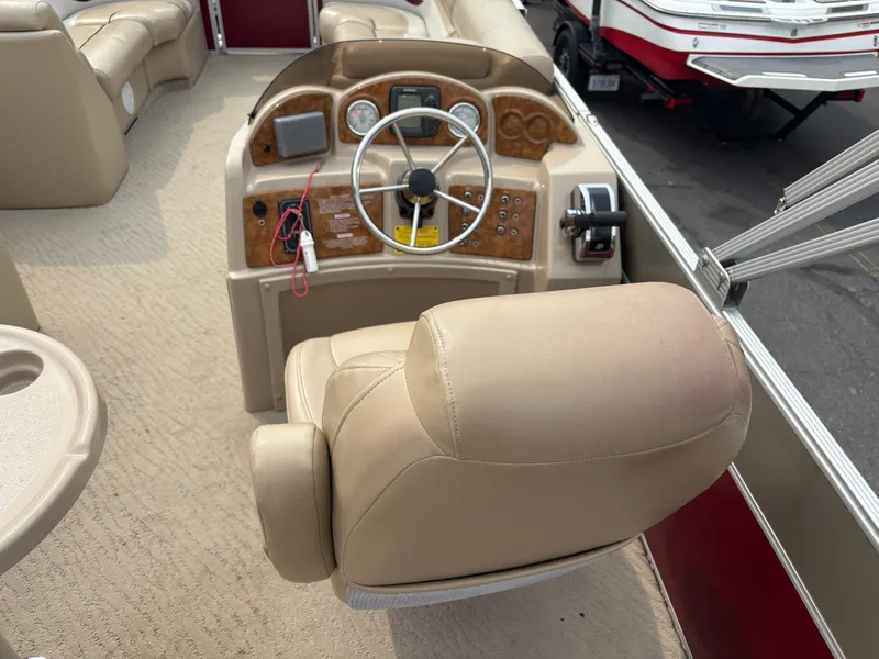 Slide: The Image of The image shows the cockpit of a 2012 Crest Classic 230L with a beige seat and dashboard. - 14