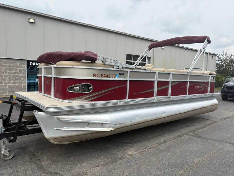 Slide: The Image of A red Crest pontoon boat, model Classic 230L, year 2012, is on a trailer. - 2