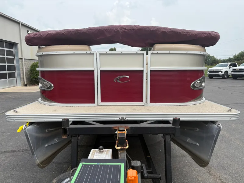 Slide: The Image of A 2012 Crest Classic 230L pontoon boat with a red and silver hull, on a trailer. - 3