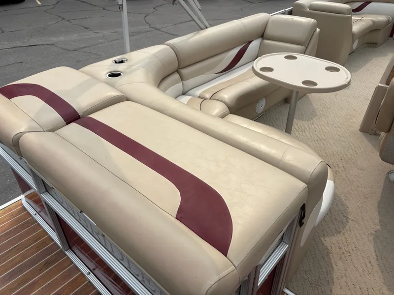 Slide: The Image of The image shows the beige and maroon seating area of a 2012 Crest Classic 230L pontoon boat. - 16