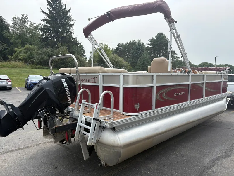 Slide: The Image of A red Crest pontoon boat, model Classic 230L, year 2012, with a Mercury outboard motor. - 5