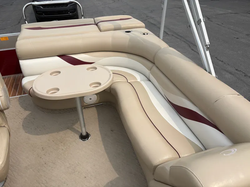 Slide: The Image of The image shows the beige and cream seating area of a 2012 Crest Classic 230L pontoon boat. - 13