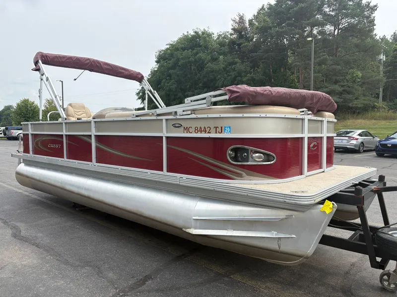 Slide: The Image of A red Crest pontoon boat, model Classic 230L, year 2012, is on a trailer. - 4