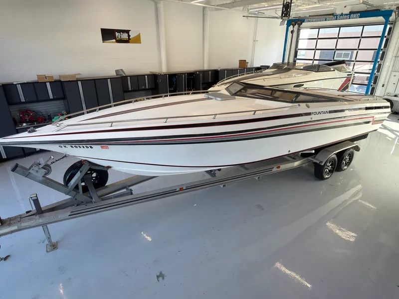 Slide: The Image of A white 1988 Fountain Sport boat on a trailer in a garage. - 4