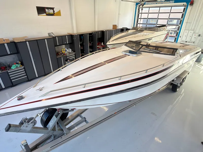 Slide: The Image of A white 1988 Fountain Sport boat on a trailer in a garage. - 3