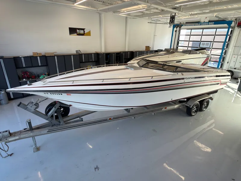 Slide: The Image of A white 1988 Fountain Sport boat on a trailer in a garage. - 2