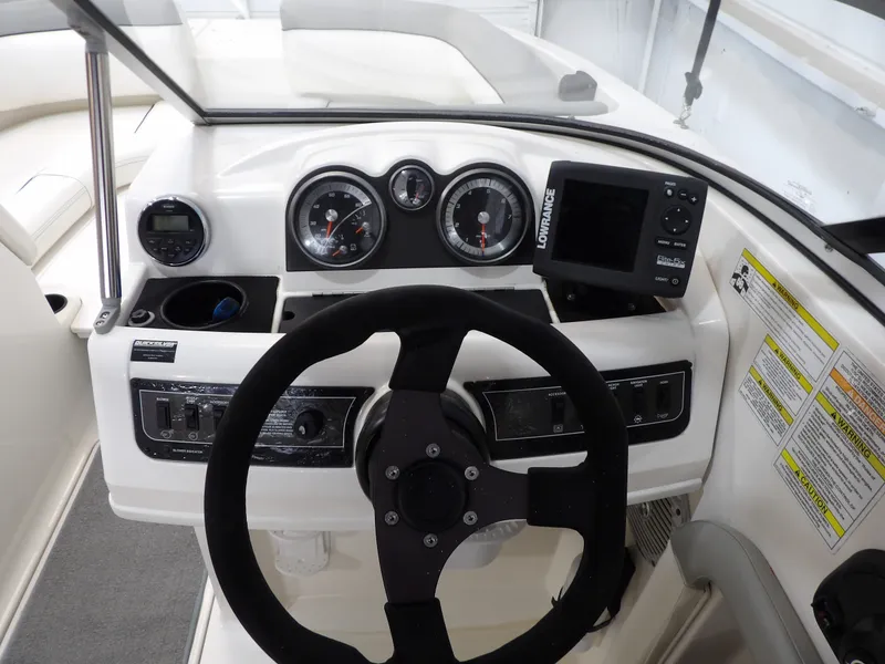 Slide: The Image of The image shows the helm of a 2013 Bayliner 190 Deck Boat with instruments and a GPS device. - 15