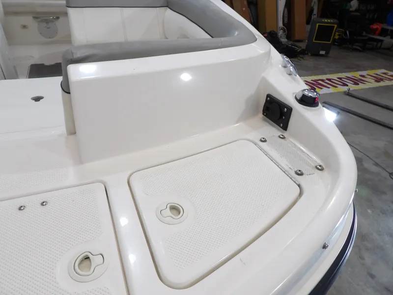 Slide: The Image of The image shows the stern of a 2013 Bayliner 190 Deck Boat with storage hatches. - 11