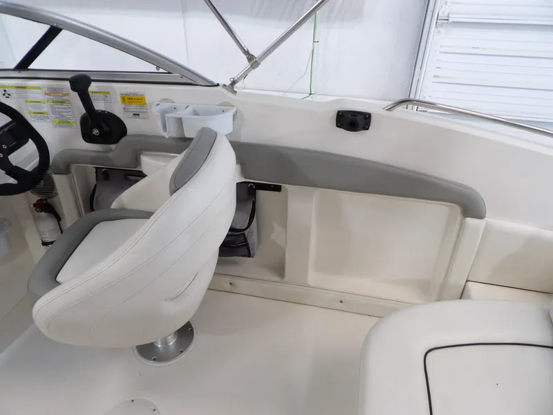 Slide: The Image of The image shows the interior of a 2013 Bayliner 190 Deck Boat with a white seat. - 18