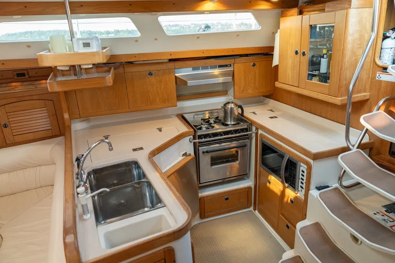 Slide: The Image of Cozy kitchen in a 2000 Catalina 400 MkII yacht with wooden cabinetry and modern appliances. - 24
