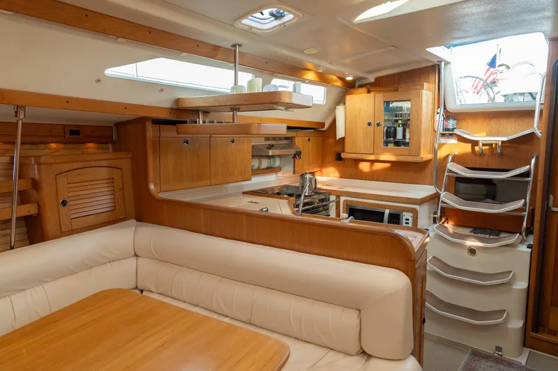 Slide: The Image of Interior of a 2000 Catalina 400 MkII sailboat with wooden cabinetry and cozy seating area. - 26