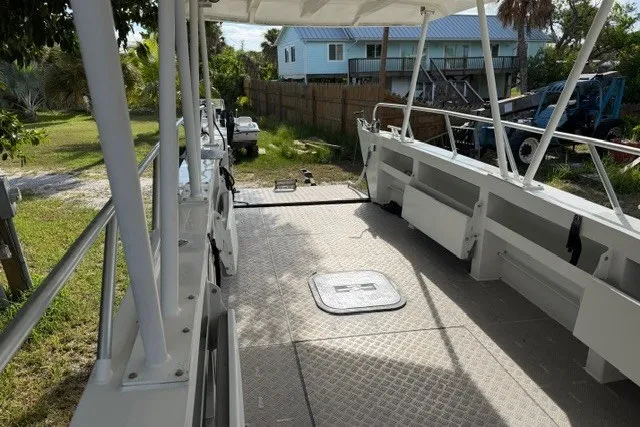 Slide: The Image of 2022 Gospel Boat Florida Landing Craft 9m with spacious deck, docked near residential area. - 2