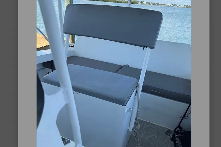 Slide: The Image of Interior seating of 2022 Gospel Boat Florida Landing Craft 9m, featuring gray cushions and scenic water view. - 7