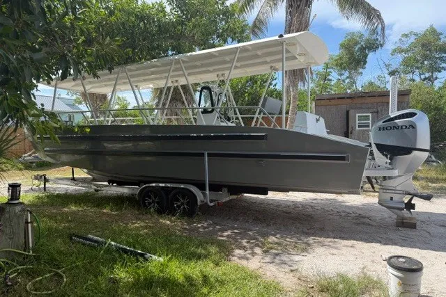 Slide: The Image of 2022 Gospel Boat Florida Landing Craft 9m with Honda engine on trailer, parked outdoors. - 3
