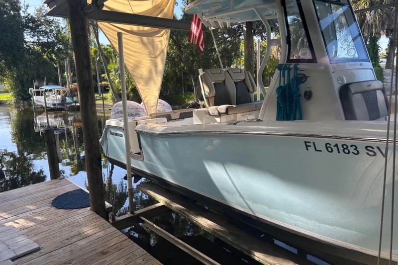The Image of 2021 Tidewater 272 CC Adventure boat docked in a serene waterfront setting. - 1