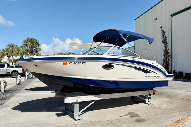 The Image of 2015 Chaparral 224 Sunesta boat with blue canopy on display outdoors. - 0