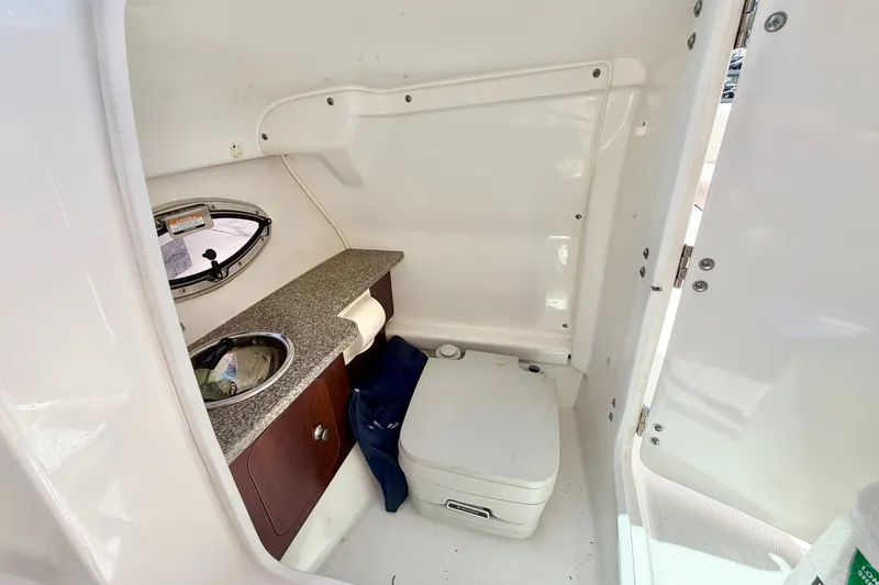 Slide: The Image of Interior of 2015 Chaparral 224 Sunesta boat with compact bathroom amenities. - 13