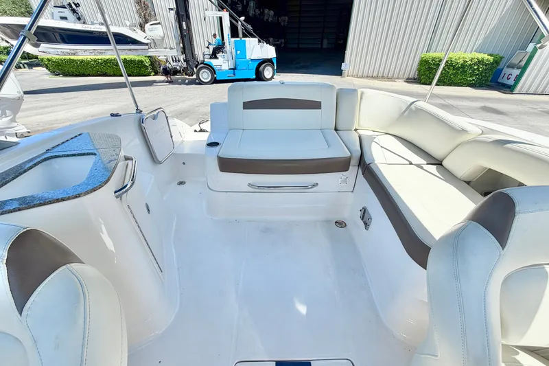 Slide: The Image of 2015 Chaparral 224 Sunesta boat interior with white seating and storage compartments. - 9