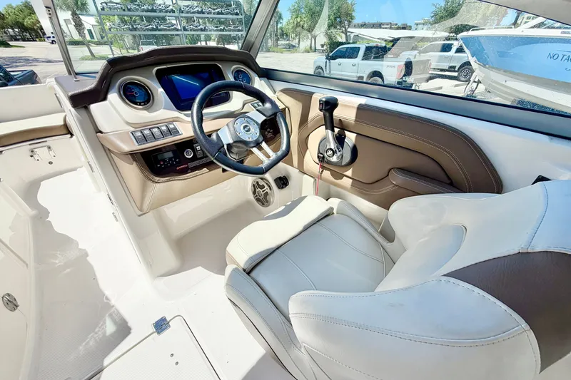 Slide: The Image of 2015 Chaparral 224 Sunesta boat cockpit with steering wheel and control panel. - 16