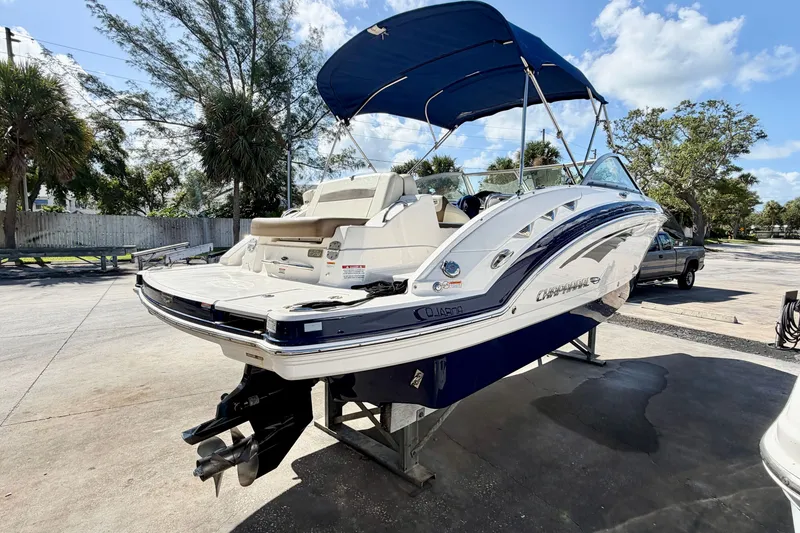 Slide: The Image of 2015 Chaparral 224 Sunesta boat with blue canopy, parked outdoors on a sunny day. - 6